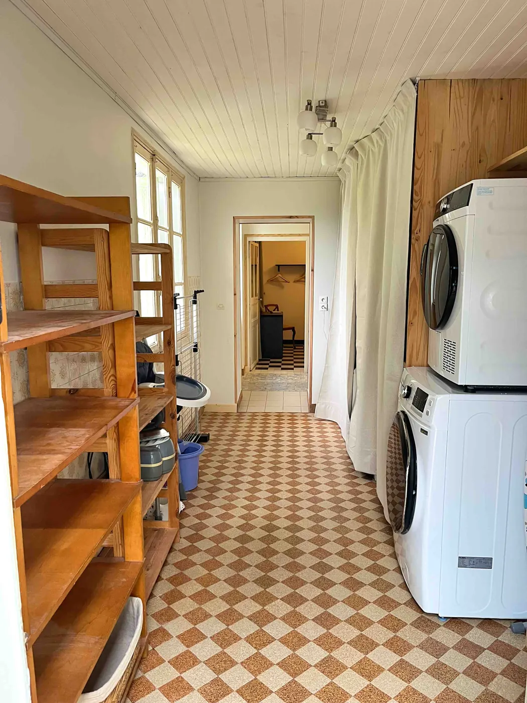 La buanderie rénovée, plafond blanc, étagères et lave-linge