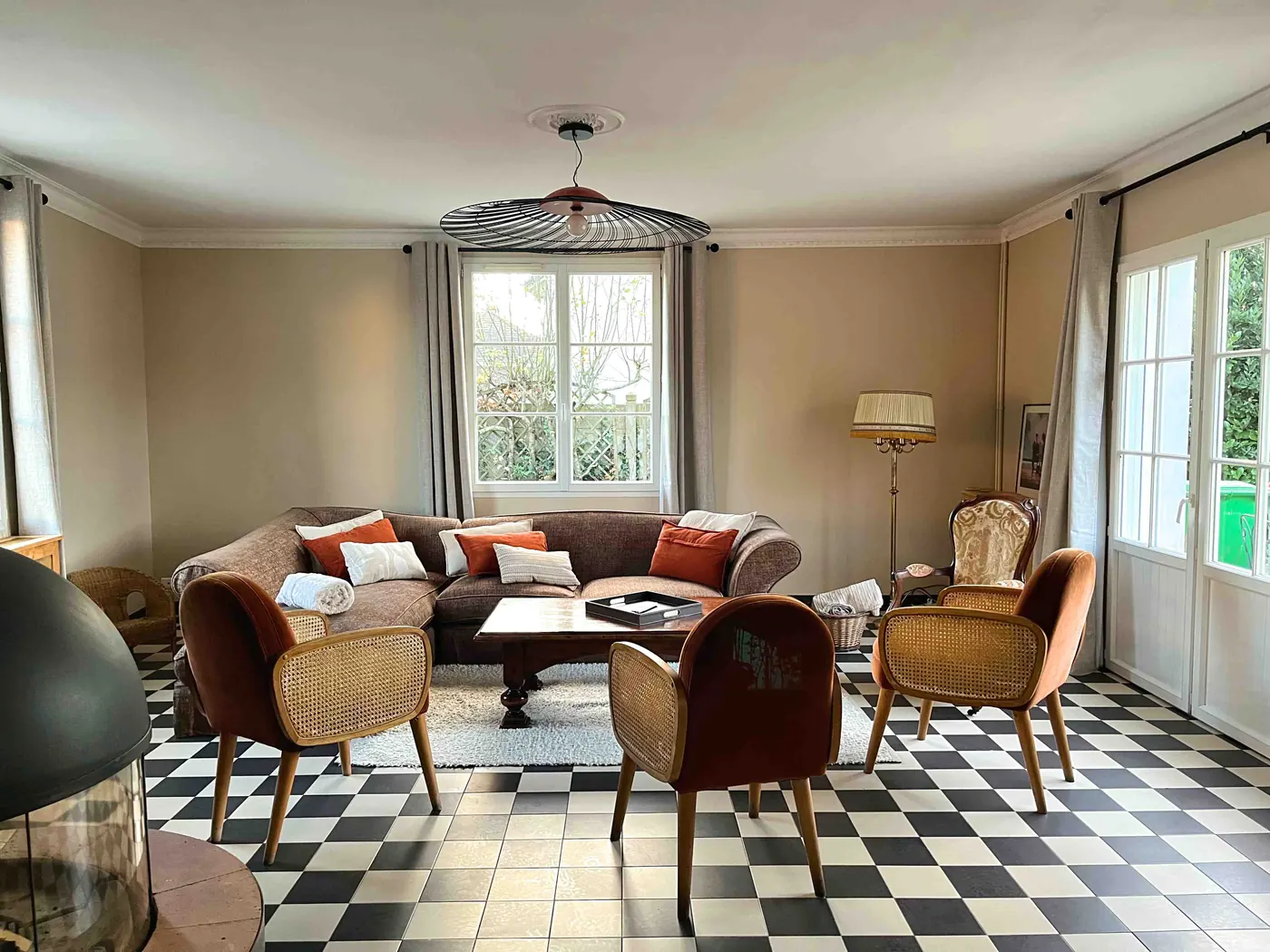 Le salon rénové vu vers la fenêtre, fauteuils et suspension